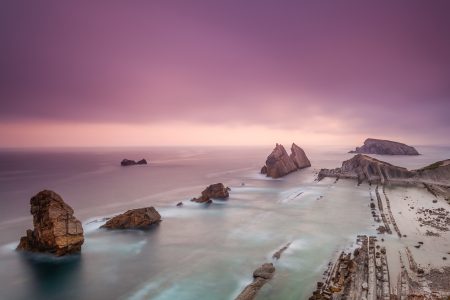 Costa con sistema rocoso y cielo morado